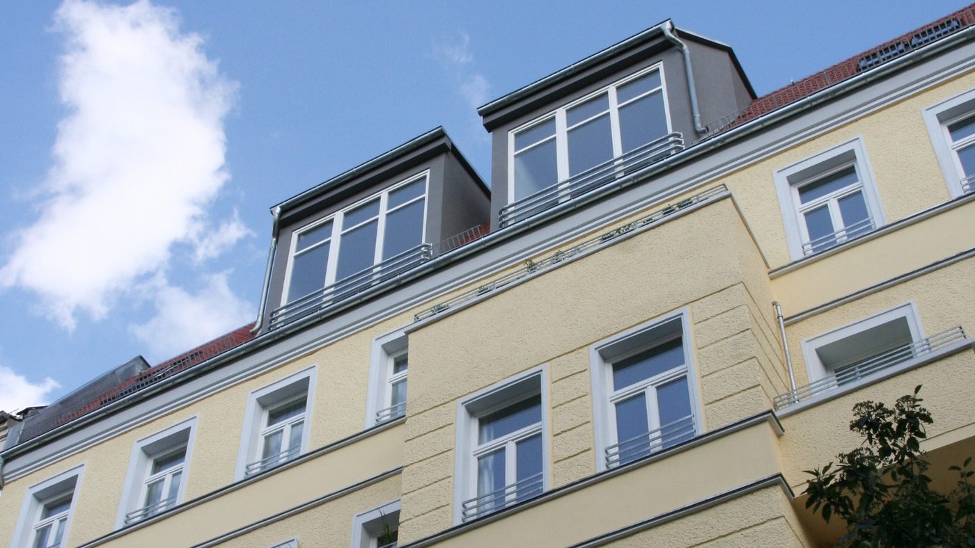 Gelbe Altbaufassade mit Dachgauben